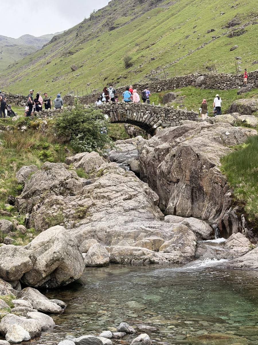 Group crossing stone bridge in Borrowdale