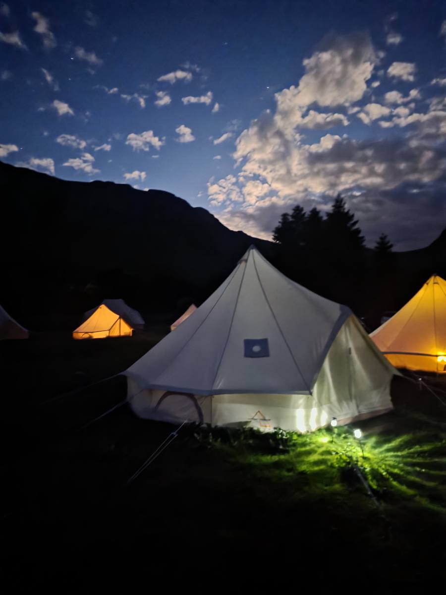 Bell tents glowing at night